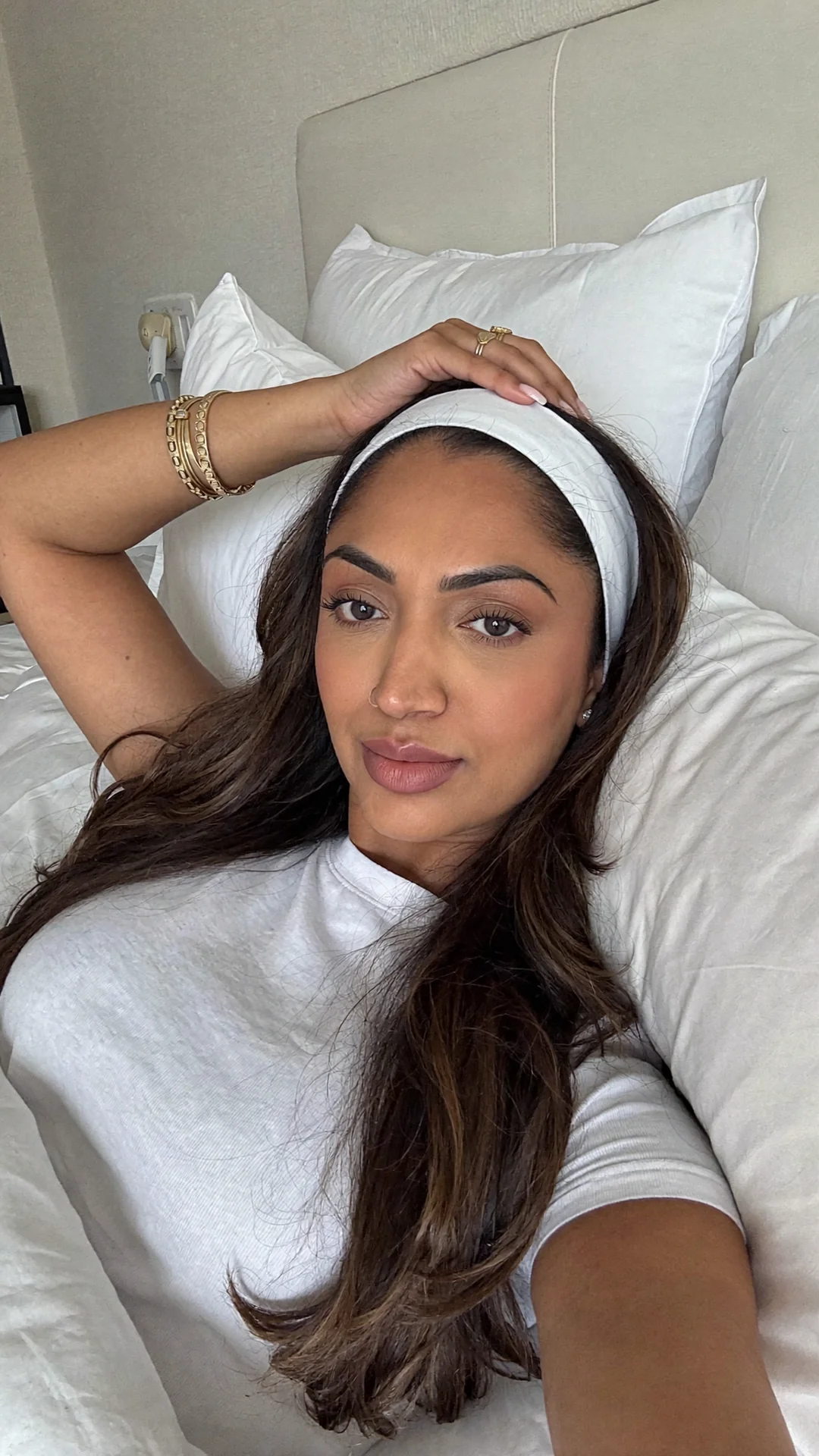 Sonia’s avatar in a white top and headband reclining against white pillows