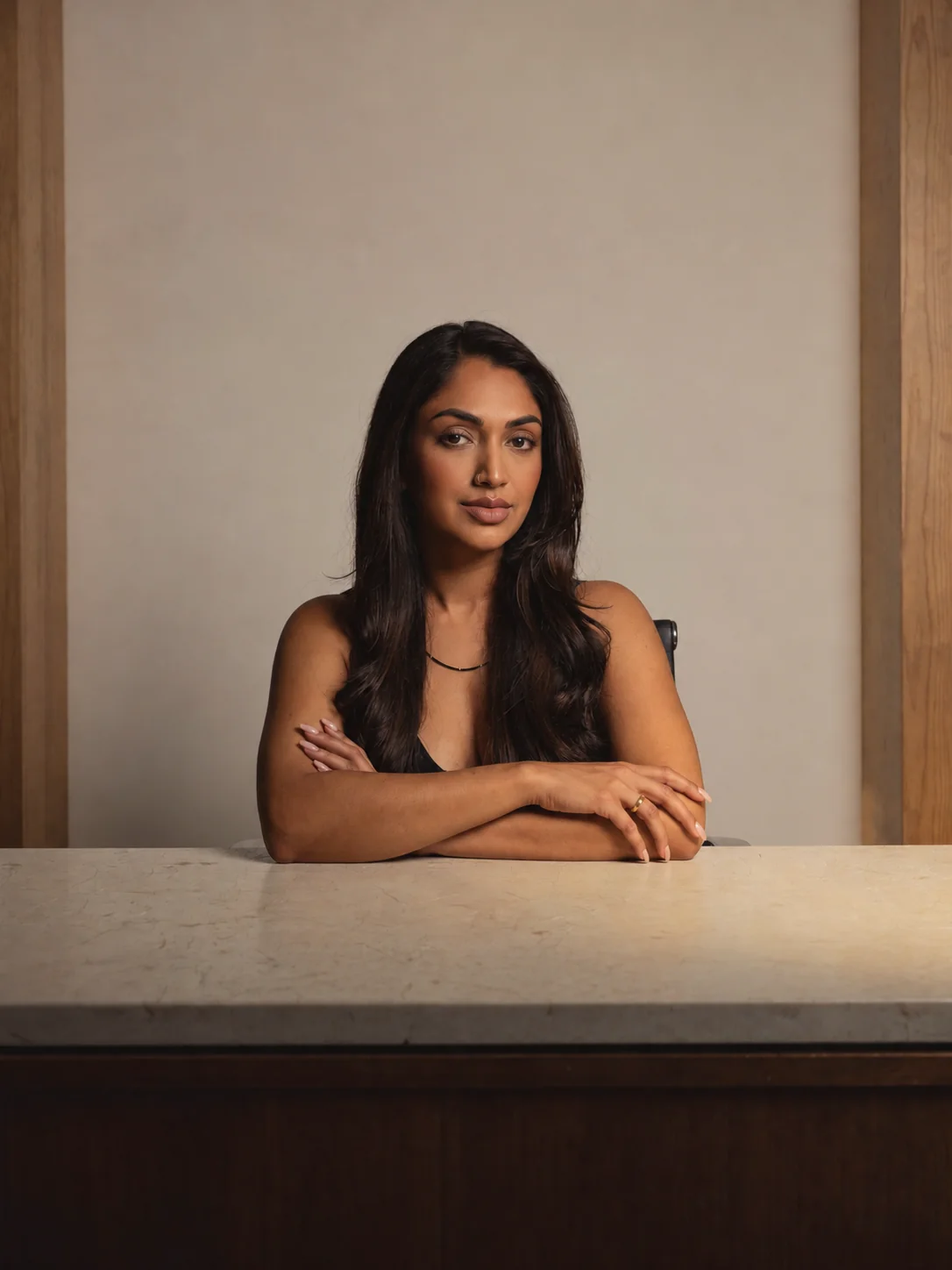 Sonia’s avatar seated with folded arms behind a marble table